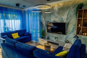 a living room with a blue couch and a tv at Oaza Brzozowa in Stradomia Wierzchnia