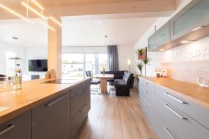 a kitchen with a counter top and a living room at Ferienhaus Eastside - Niendorf in Häven