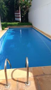 a large blue swimming pool with two metal handles at Villa Anfa in Casablanca