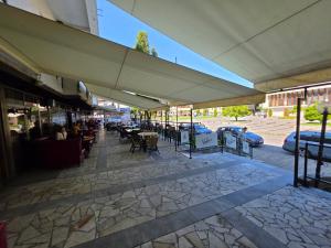 a patio with tables and chairs under a large umbrella at Комплекс ,,Трявна" in Tryavna