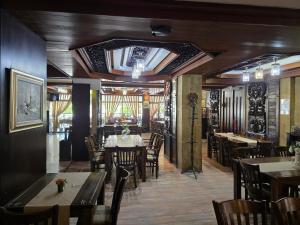 a dining room with tables and chairs and a ceiling at Комплекс ,,Трявна" in Tryavna