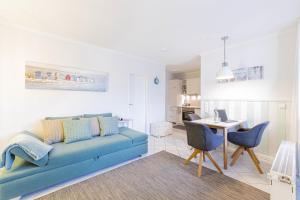 a living room with a blue couch and a table at Ferienwohnung Urlaubsflair in Timmendorfer Strand +26 photos