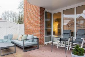 a patio with a couch and a table and chairs at Ferienwohnung Urlaubsflair in Timmendorfer Strand
