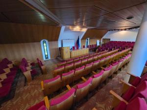 an empty auditorium with red chairs in a church at Комплекс ,,Трявна" in Tryavna