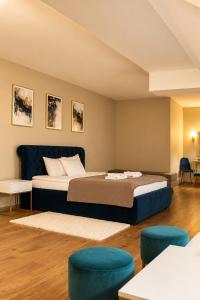 a bedroom with two beds and two blue chairs at Hotel Vinnica in Wieliczka +41 photos