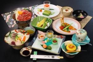 a table topped with plates and bowls of food at Ryokan Kibun in Tsuiki