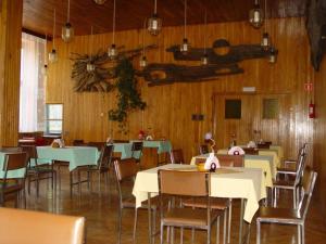 a dining room with tables and chairs and wooden walls at Ośrodek Świt Wilga in Wilga