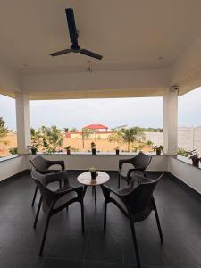 a balcony with chairs and a table and a large window at Ocean Kala Crest in Cheyūr