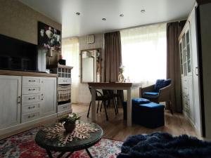 a living room with a table and a kitchen at Station and Border Comfort Art and Cats Inn - Комфорт у вокзала и границы Арт и Кот in Narva