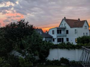 a white house with a fence in front of a sunset at Ferienapartment Erdmann in Münster