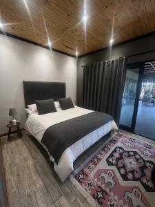 a bedroom with a large bed and a rug at FollyFoot Manor in Midrand