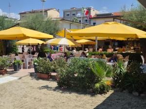 a restaurant with yellow umbrellas and people sitting at tables at Apt Versilia in Viareggio