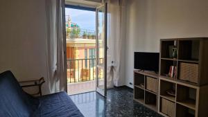 ein Wohnzimmer mit Sofa, Fernseher und Balkon in der Unterkunft Rapallo Riviera in Rapallo