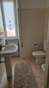 ein Badezimmer mit Waschbecken, Toilette und Fenster in der Unterkunft Rapallo Riviera in Rapallo + 9 Fotos