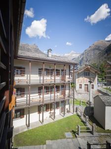 a view of a building with mountains in the background at Indren Hus in Alagna Valsesia