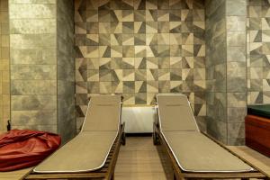 two empty benches in a waiting room with tiles at O'clock bed & SPA in Burgas