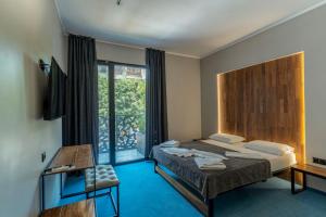 a bedroom with a bed and a large window at O'clock bed & SPA in Burgas