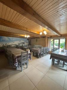 a dining room with tables and chairs and a mural at Gostynnyi Dvir u Marichky in Lazeshchyna