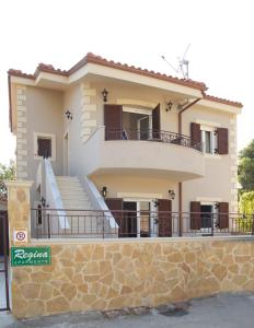 a house with a balcony and stairs on it at Regina Apartments in Lassi