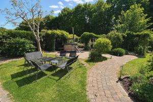 a patio with a table and chairs in the grass at The Poplar Place - Spacious Comfort, Hot Tub in Private Garden in Zeewolde +45 photos