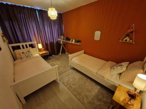 a small bedroom with two beds and a window at Kintsugi in Alphen aan den Rijn