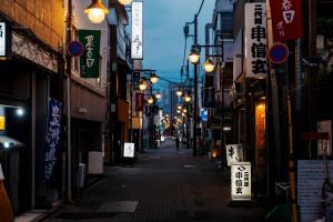an alley with street lights in an asian city at night at 余韻 -YOIN- Kofu 甲府中心街で夜を楽しむ貸切宿 in Kofu