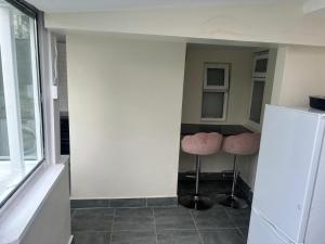 a kitchen with two stools in a room with a refrigerator at Newbridge house in Newbridge