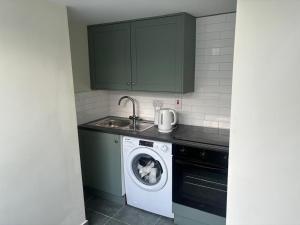 a kitchen with a washing machine and a sink at Newbridge house in Newbridge