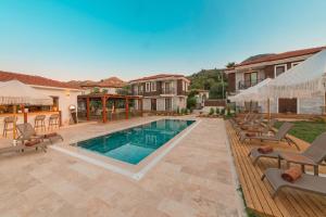 a backyard with a swimming pool and a house at Kiraz Vela Selimiye in Marmaris
