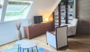 a living room with a tv and a table and stool at Ático LA FLOR DEL SOL in Canfranc