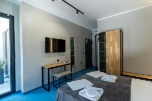 two beds in a room with a desk and a tv at O'clock bed & SPA in Burgas +103 photos