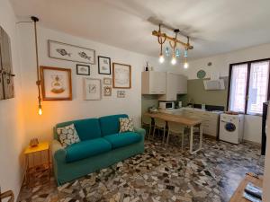 a living room with a blue couch and a kitchen at Coramino in Chioggia