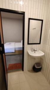 a bathroom with a sink and a mirror and a bed at Ratu Roso Resort in Malang +55 photos