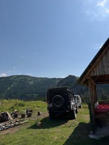 a jeep parked in a field next to a house at ILDO Guesthouse in Asim Zeneli