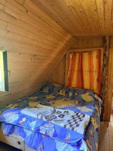 a bed in a cabin with a wooden ceiling at ILDO Guesthouse in Asim Zeneli
