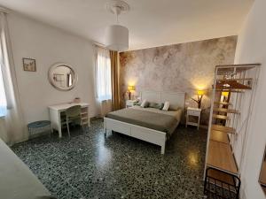a bedroom with a bed and two tables and a mirror at Coramino in Chioggia