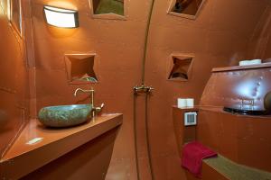 a bathroom with an orange wall with a sink at Baumhaushotel - Die geheime Welt von Turisede - Kulturinsel Einsiedel in Zentendorf