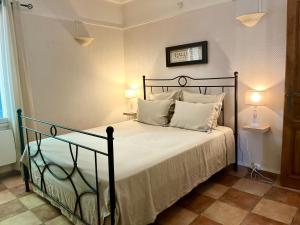a bedroom with a black bed with white pillows at Mas des 4 fontaines in Robion en Luberon +77 photos