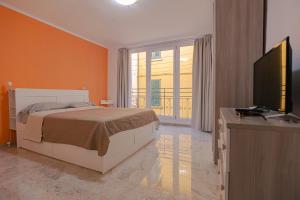 a bedroom with a bed and a flat screen tv at Magnifica Terrazza - Lake View & Wi-Fi in Gardone Riviera