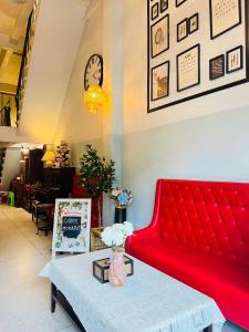 a red couch in a room with a table at Baan Bangrak Home in Bang Rak