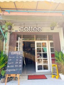 a coffee shop with a sign in front of it at Baan Bangrak Home in Bang Rak