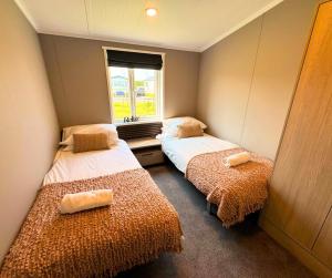 a small room with two beds and a window at Hilltop Holiday Park in Portrush +33 photos