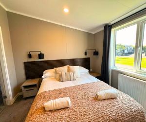 a bedroom with a large bed with two pillows on it at Hilltop Holiday Park in Portrush