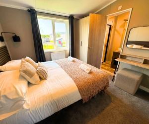 a bedroom with a bed and a large window at Hilltop Holiday Park in Portrush