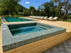 a swimming pool with lounge chairs around it at Pensiunea Coronita in Vişeu de Sus