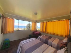 a bedroom with two beds and a large window at Kusk'a Lodge in Puno
