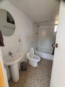 a bathroom with a sink and a toilet and a tub at Kusk'a Lodge in Puno