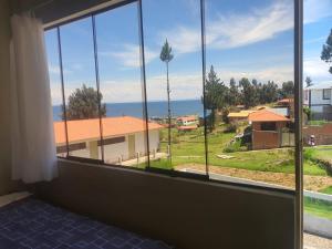 a room with a window with a view of the ocean at Kusk'a Lodge in Puno