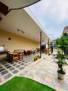an outdoor patio with tables and chairs and grass at Hotel Anaya in Pokhara