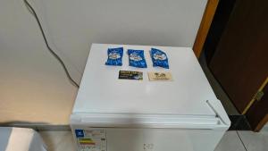 a white refrigerator with three bags of food on it at Hotel Pousada Narandiba in Narandiba
